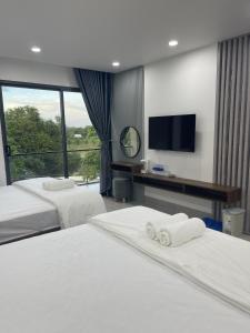 een hotelkamer met 2 bedden en een flatscreen-tv bij Lagi Beach Hotel in La Gi