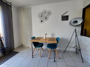 a table and chairs in a room with a camera at Studio sur les rives d'allier in Moulins
