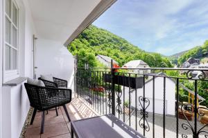 einen Balkon mit Stühlen und Bergblick in der Unterkunft Hotel Lipmann "Am Klosterberg" in Beilstein