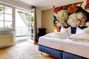 1 dormitorio con 1 cama con pared de flores en Hotel Lipmann "Am Klosterberg" en Beilstein