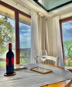 una mesa con una botella de vino y dos copas en Agriturismo La Corte del Sole en Siena