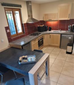 uma cozinha com uma mesa com uma bandeja em Appartement entre Sisteron et Gorges de la Méouge " Les Hauts de Toscane " em Ribiers