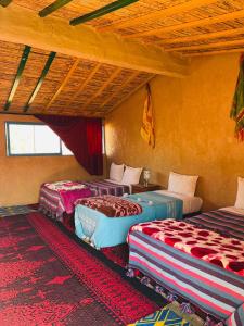 a room with three beds in a room at Bivouac Lot Of Stars in Ouarzazate