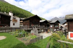 a group of buildings with mountains in the background at Chalet Heimeli in Saas-Fee