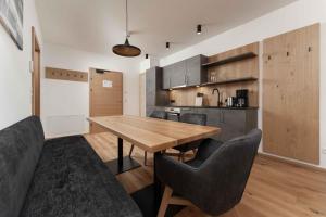 cocina y comedor con mesa de madera y sillas en A CASA Serenity, en Serfaus