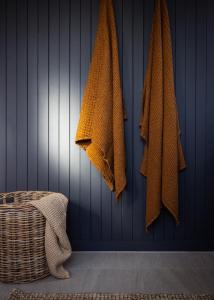 una pared azul con toallas colgando de una pared en Lobster Pot Cabin en Coles Bay