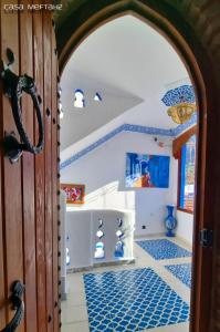 una porta aperta per una camera con piastrelle bianche e blu di Casa Meftah Blue a Chefchaouen