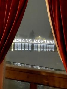 una vista desde una ventana con el signo mgm montgomery en Chalet Familial Sublime en Crans-Montana