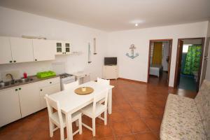 a kitchen and dining room with a white table and chairs at Appartamento LULA. Stella Maris Exclusive in Calheta Do Maio