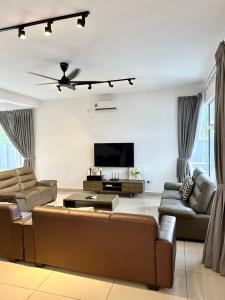 - un salon avec un canapé et une télévision dans l'établissement Hom Villa 5rm 12-22 pax Wifi Netflix BBQ SteamBoat Games Beach Water Park, à Kota Tinggi