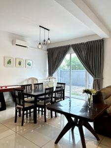 - une salle à manger avec une table, des chaises et un piano dans l'établissement Hom Villa 5rm 12-22 pax Wifi Netflix BBQ SteamBoat Games Beach Water Park, à Kota Tinggi