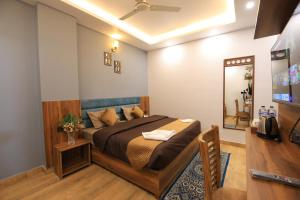 a bedroom with a bed and a television in it at Hotel Mahadev Rishikesh in Rishīkesh