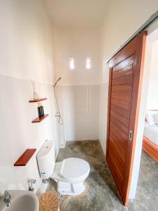 uma casa de banho com um WC e um lavatório em Turtle House Surf & Stay em Airsatang