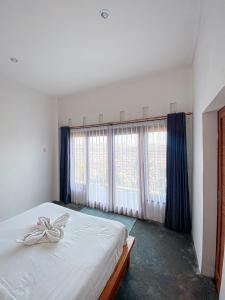 um quarto com uma cama branca e cortinas azuis em Turtle House Surf & Stay em Airsatang
