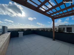 une terrasse avec une pergola en bois sur le toit dans l'établissement Appartement duplex dernier étage - vue panoramique, à Bagneux