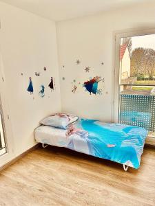 A bed or beds in a room at Disneyland Paris Familly Appart - 7 minutes Disney - Parking - Netflix - Wifi - BILLET DISNEY 80 euros