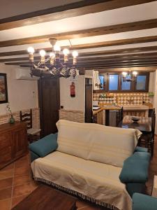 ein Wohnzimmer mit einem Sofa und einer Küche in der Unterkunft Casa Rural LA BODEGA, ofrece cata de vino gratis in Horche