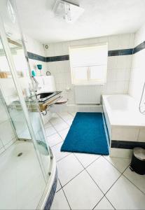 bagno con doccia e tappeto blu di Landhaus Bergheimat in Burgberg für bis zu 14 Personen a Burgberg im Allgäu