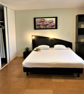 Un dormitorio con una cama grande con sábanas blancas. en ApartHotel Sainte-Marthe, en Aviñón