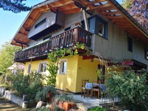 una casa gialla con balcone e tavolo di Un superbe chalet tout proche de Mens a Mens