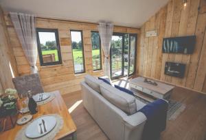 ein Wohnzimmer mit einem Sofa und einem Tisch in der Unterkunft Edgmond Lodges - Scropton in Hilton