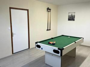 a room with a pool table in front of a door at Gîte du canal rue de la Tuilerie in Amilly