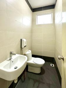 La salle de bains est pourvue de toilettes blanches et d'un lavabo. dans l'établissement Hom Villa 5rm 12-22 pax Wifi Netflix BBQ SteamBoat Games Beach Water Park, à Kota Tinggi