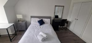 ein Schlafzimmer mit einem Bett mit weißen Laken und blauen Kissen in der Unterkunft Double Bedroom Ensuite in Rochester