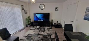 ein Wohnzimmer mit einem Flachbildfernseher an der Wand in der Unterkunft Double Bedroom Ensuite in Rochester