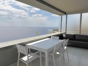 a white table and chairs on a balcony with the ocean at SARA RIVIERA Costa Plana in Cap d'Ail