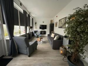 uma sala de estar com sofás e um vaso de plantas em Pension Auberge de Dael em Valkenburg