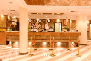 a lobby with a bar with clocks on the wall at Al Andalus Palace 1 Hotel in Medina