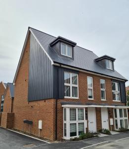ein rotes Backsteinhaus mit einem schwarzen Dach in der Unterkunft Double Bedroom Ensuite in Rochester