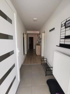 トゥズラにあるApartment Mejdanの白い壁の廊下、テーブル付きの部屋 +9枚の写真