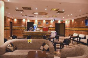 a lobby with couches and chairs and a bar at Manazel AlSafiyah Hotel in Medina