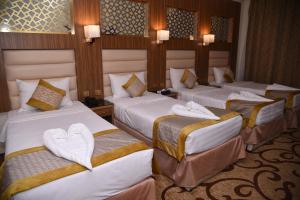 a hotel room with three beds with hearts on them at Al Andalus Palace 1 Hotel in Al Madinah