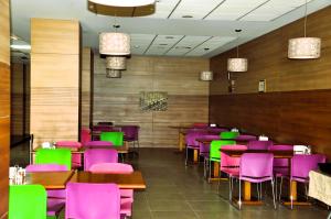 a dining room with purple and green chairs and tables at Göygöl Olimpiya İdman Kompleksi in Xanlar