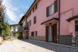 une rangée de maisons roses avec une allée dans l'établissement casa vacanze la TORRETTA di Silvana & Valter, à Seriate