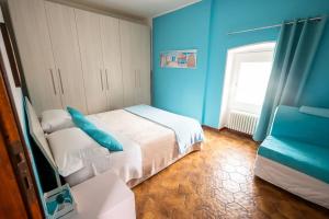 una camera blu con un letto e una finestra di casa vacanze la TORRETTA di Silvana & Valter a Seriate