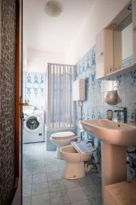 a bathroom with a toilet and a sink and a washing machine at casa vacanze la TORRETTA di Silvana & Valter in Seriate