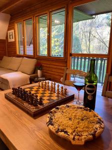 a chess board and a glass of wine on a table at Kerekerdő Apartman - Szarvaskő in Szarvaskő
