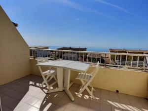 a table and chairs on a balcony with the ocean at Appartement vue mer en plein centre de Valras-Plage in Valras-Plage