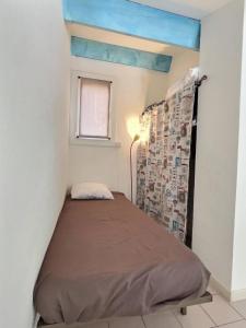 a small bedroom with a bed in a room at Appartement vue mer en plein centre de Valras-Plage in Valras-Plage