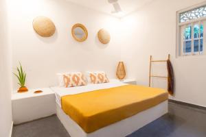 a white bedroom with a bed and a window at Coconut Cottage - Hiriketiya Beach in Hiriketiya