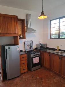 a kitchen with a refrigerator and a stove at The Landing Nanyuki Cottages in Nanyuki