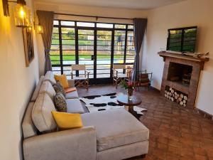 a living room with a couch and a fireplace at The Landing Nanyuki Cottages in Nanyuki