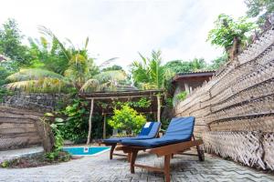 a couple of blue chairs sitting next to a pool at Coconut Cottage - Hiriketiya Beach in Hiriketiya