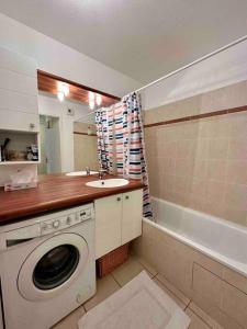 uma casa de banho com uma máquina de lavar roupa e um lavatório em T3 Georges Beljean - DABNB em Limoges
