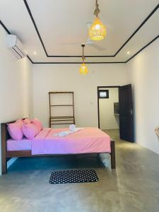 una camera da letto con un letto con cuscini rosa di Abhi Villa ad Ahangama
