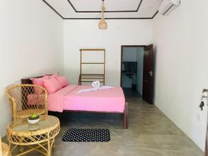una camera da letto con un letto rosa e una sedia di Abhi Villa ad Ahangama